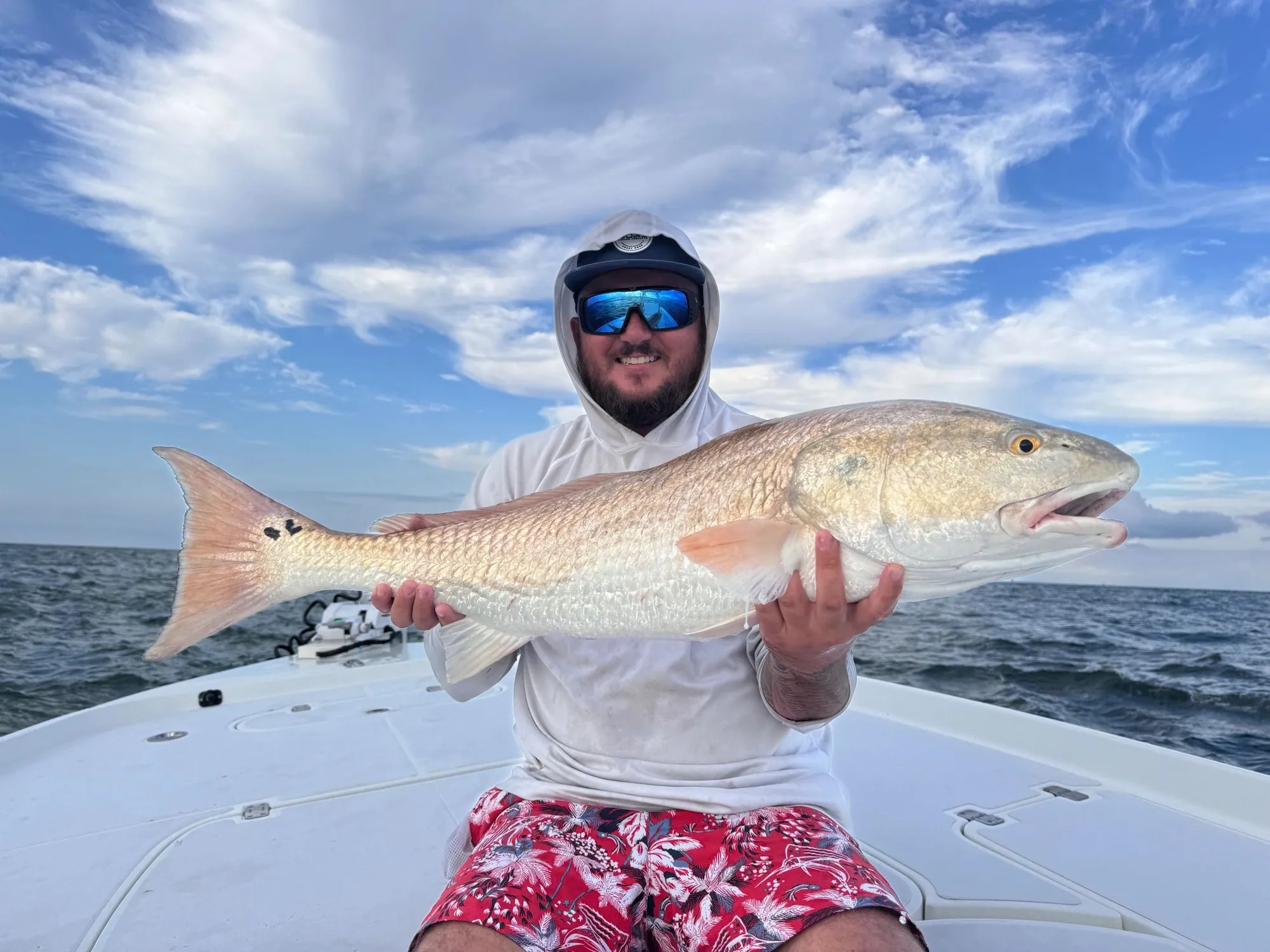 Angler holding a massive bull redfish caught in Mosquito Lagoon with Addicted Fishing Charters