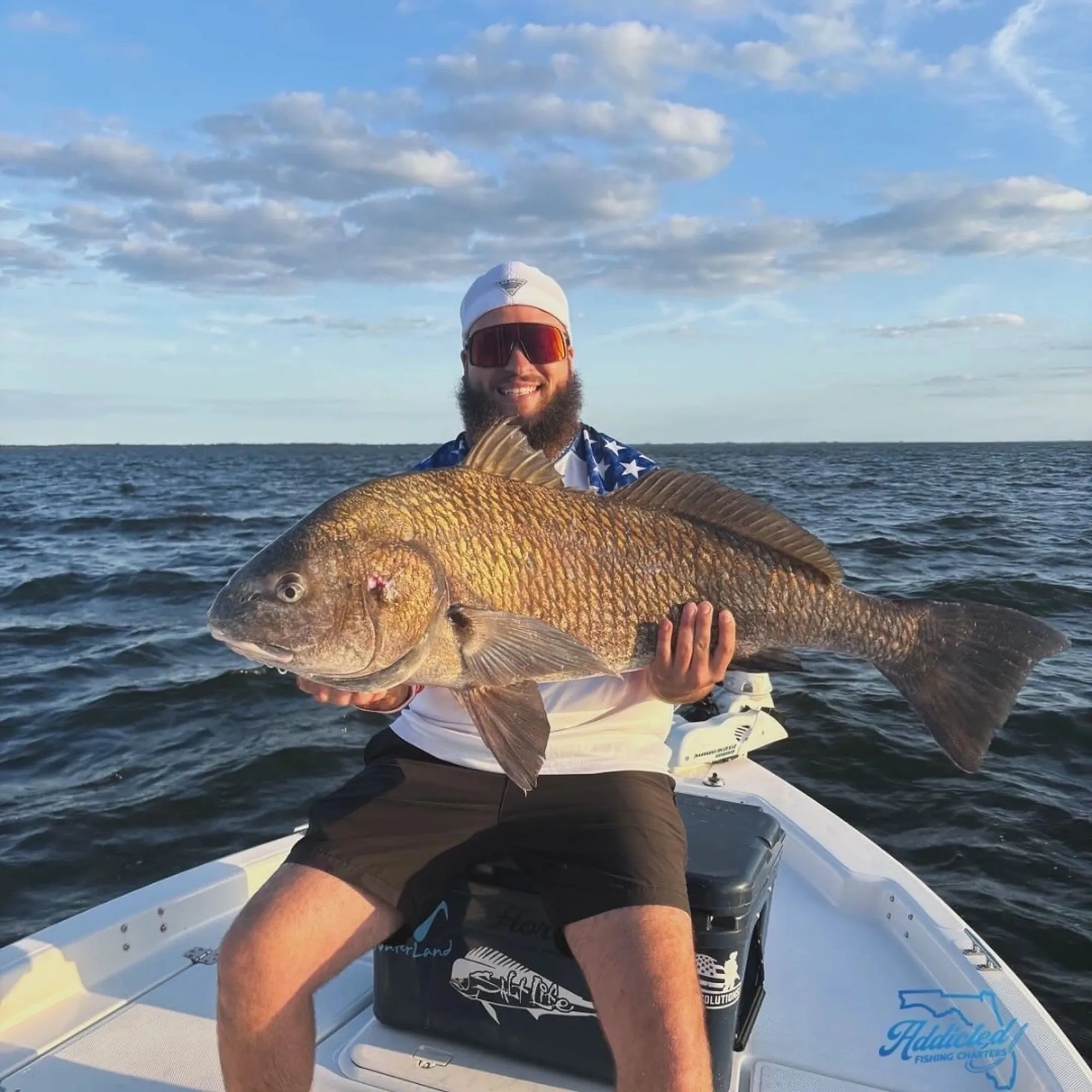 Kid with a huge redfish caught on a family fishing charter in New Smyrna Beach