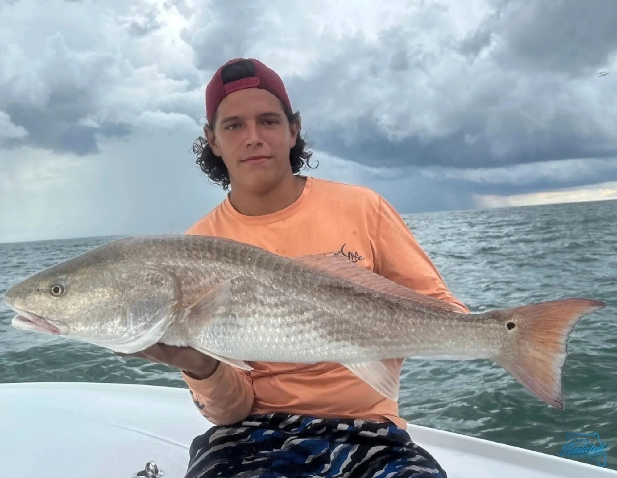 Captain Brenden holding a trophy redfish at sunset on Ponce Inlet