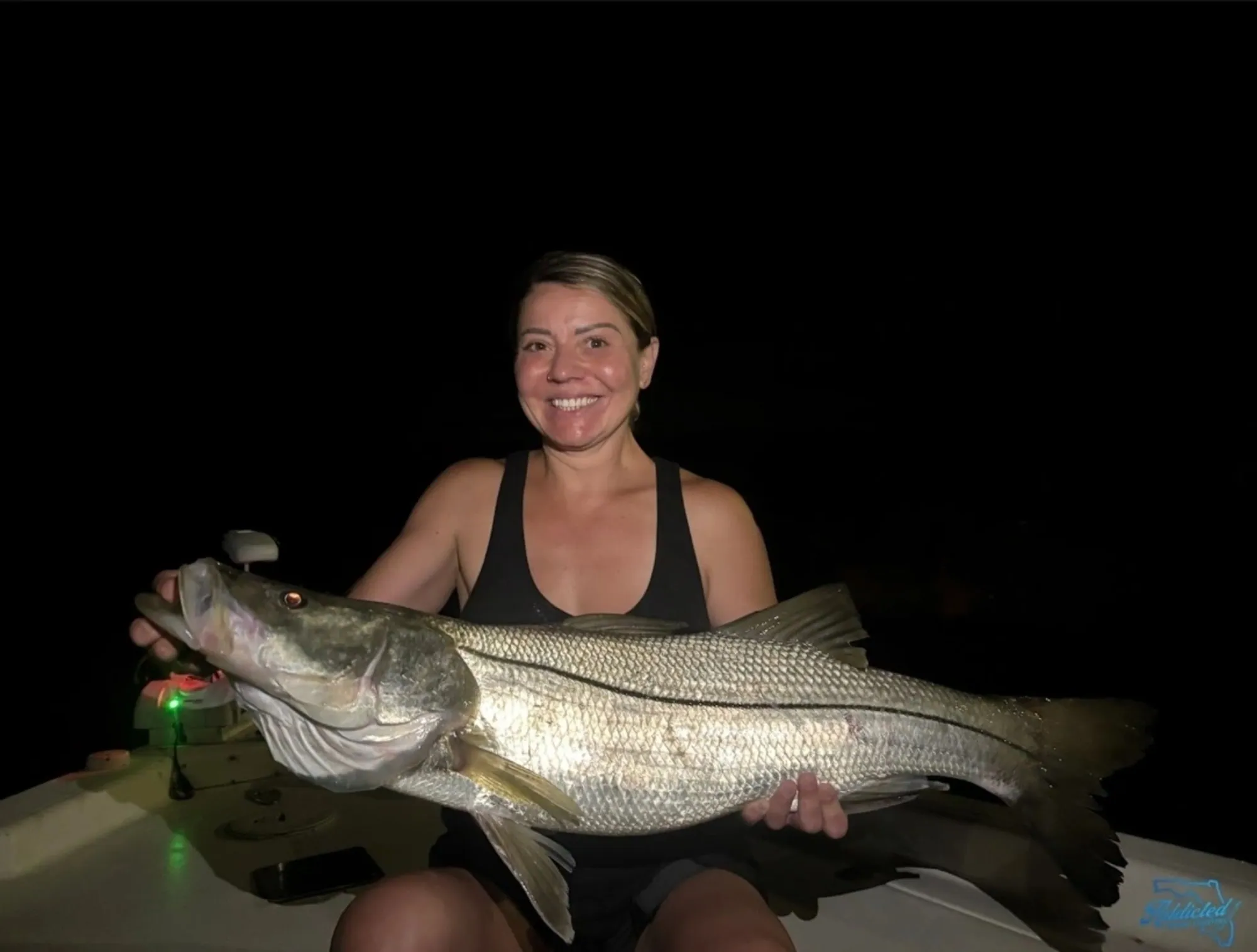 Female angler with sunset-lit redfish in Mosquito Lagoon