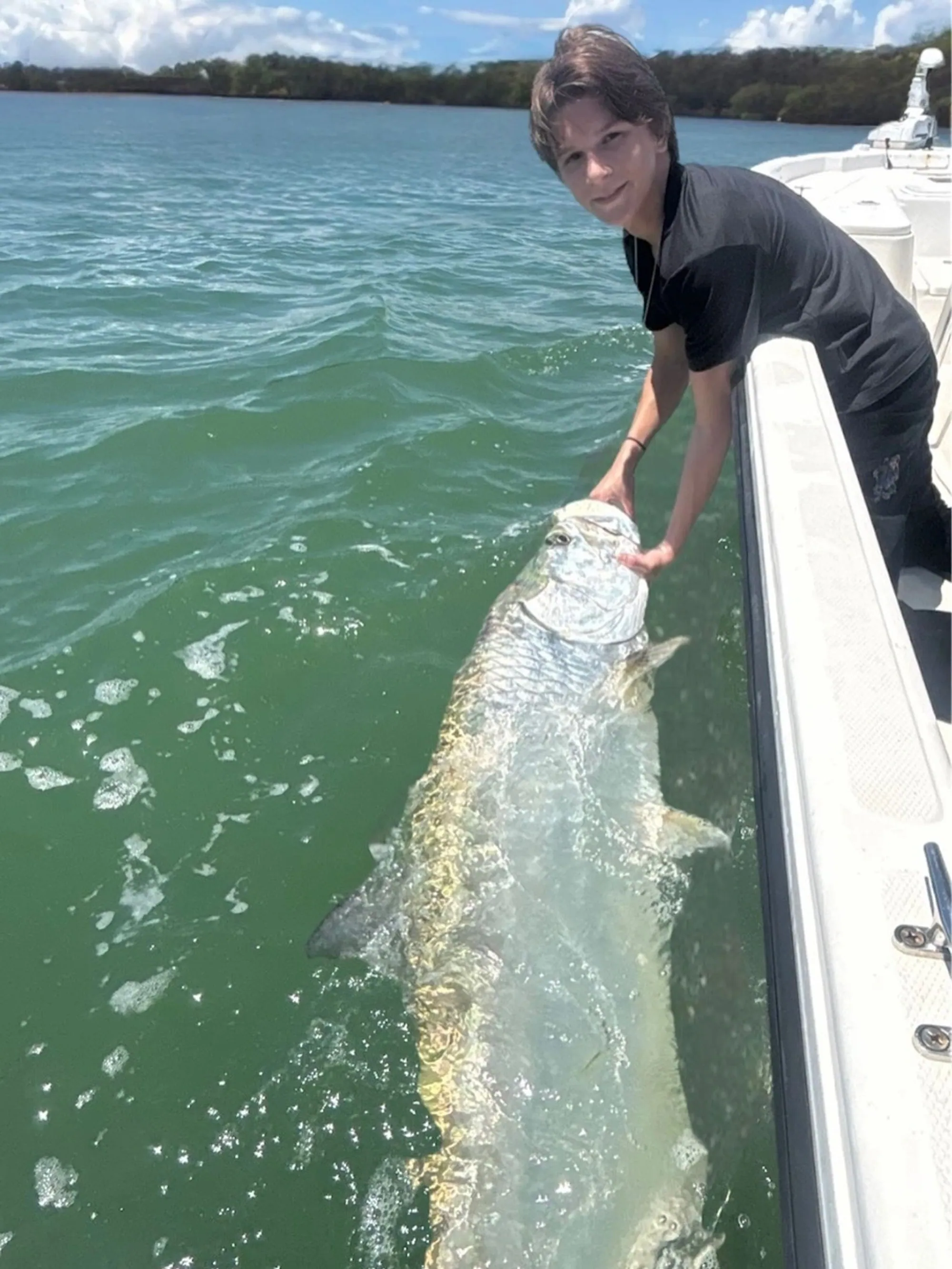 Young angler holding a huge tarpon caught near Mosquito Lagoon